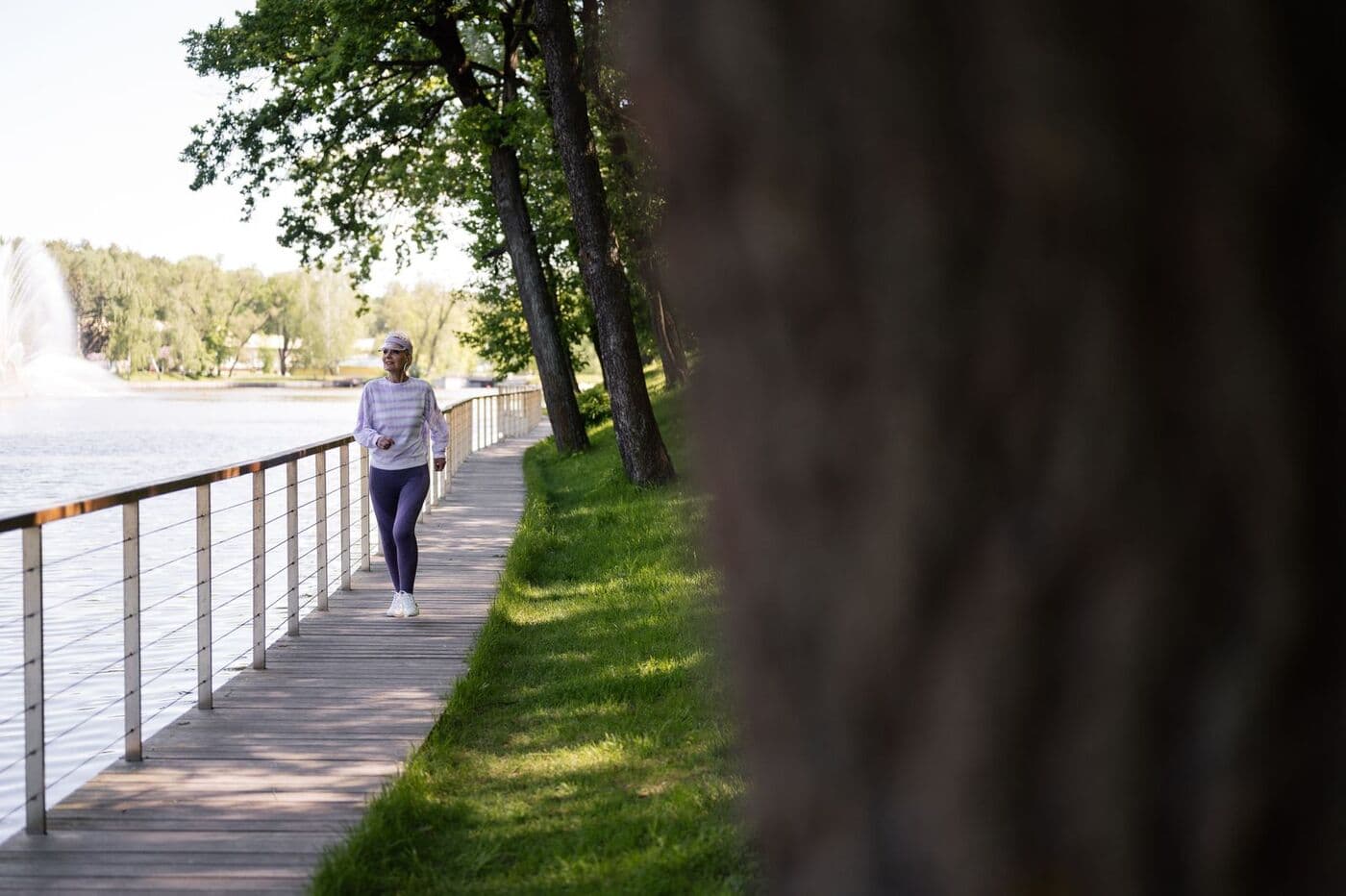 Woman walking a lakeside boardwalk in the sun